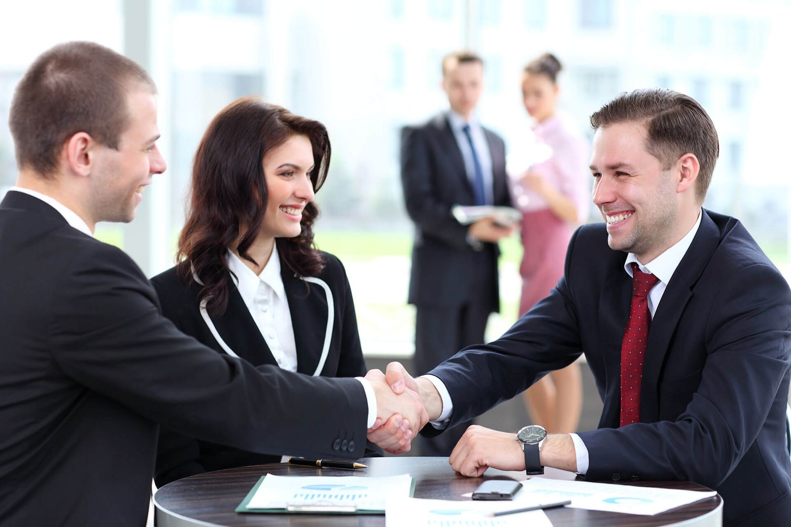 Business professionals shaking hands at meeting