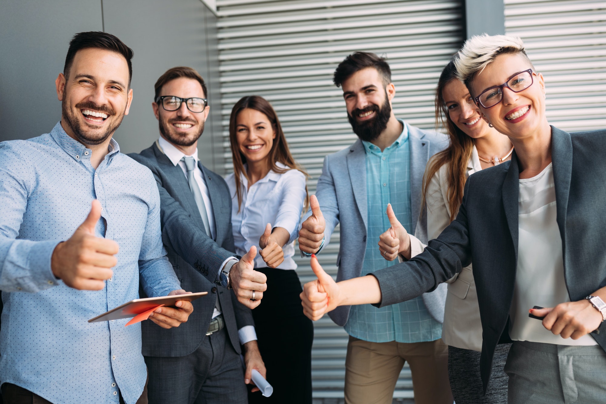 Group of smiling professionals giving thumbs up
