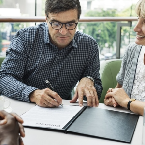 Man signing contract during business meeting